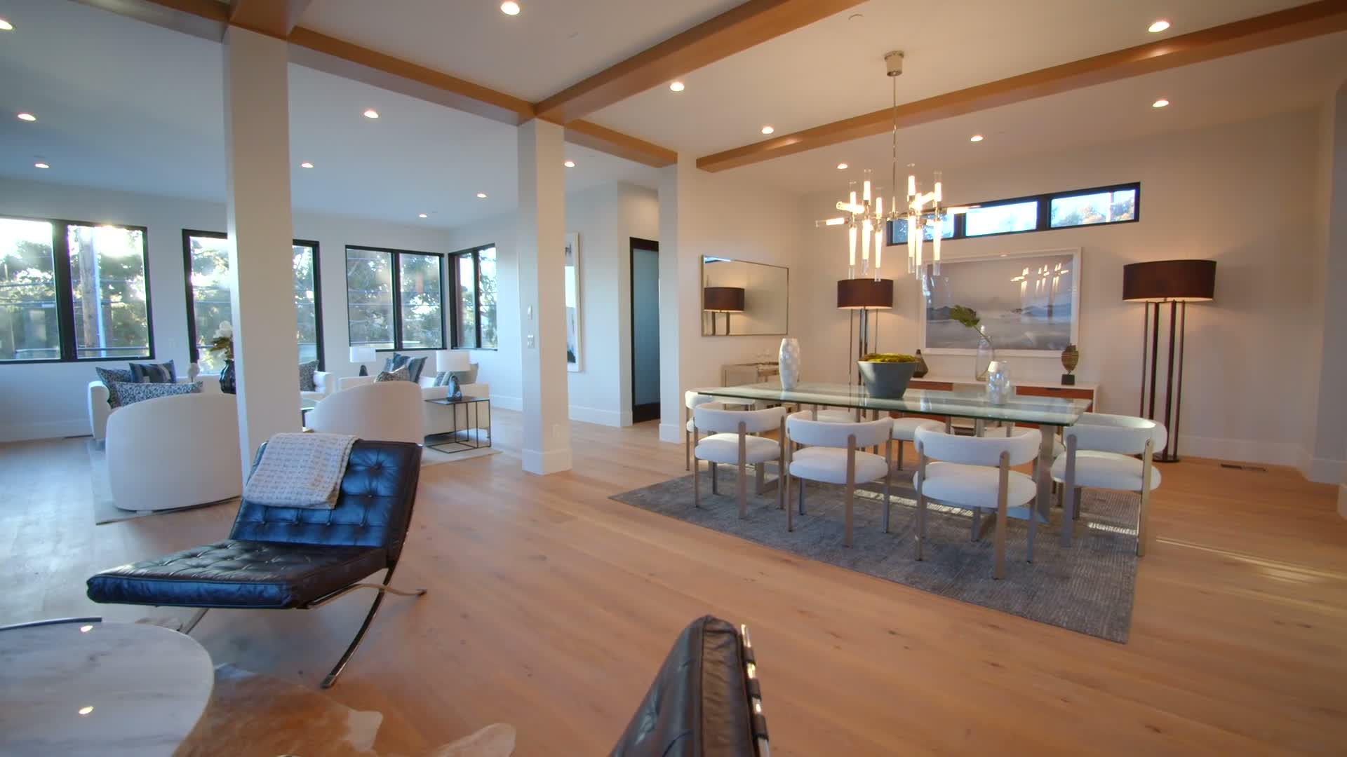 Dining and living interior with a glass table and white chairs